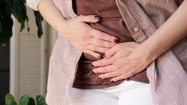 endometriumkarzinom Frau mit Händen auf unterem Bauchbereich