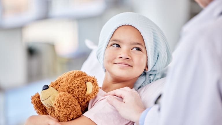 Kind mit Teddy im Bett