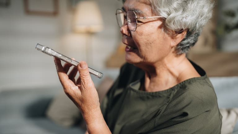 Seniorin nutzt eine KI-gestützte App auf ihrem Smartphone