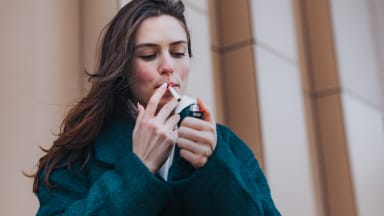 young woman smoking outdoors