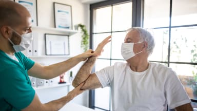 Arzt untersucht Armfunktion bei Patient