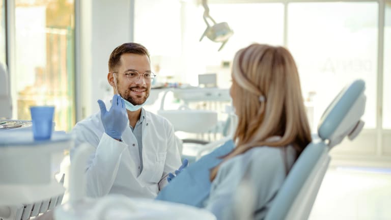 Zahnarzt im Gespräch mit einer Patientin