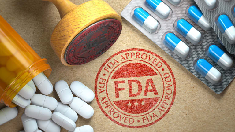 Von der FDA genehmigtes Konzept. Stempel mit der Aufschrift „FDA“ und Tabletten auf Kraftpapier.