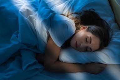 Frau schläft in einem Bett
