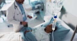 Arzt am Krankenbett eines schwer erkrankten Patienten