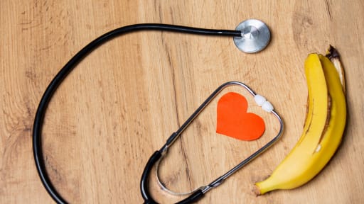 Papier Herz Stethoskop und Banane auf einem Tisch Hintergrund