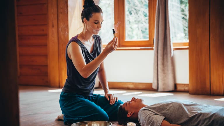 Frau mit Räucherstäbchen und Klangschale