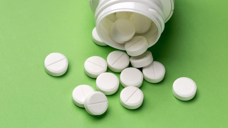 Aspirin Tabletten auf grünem Hintergrund