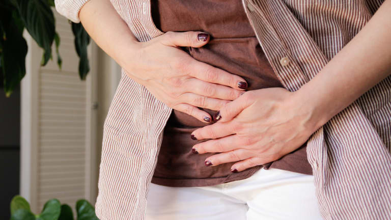 endometriumkarzinom Frau mit Händen auf unterem Bauchbereich