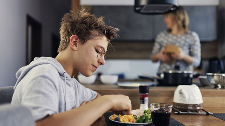 Teenager mit Rührei zum Frühstück