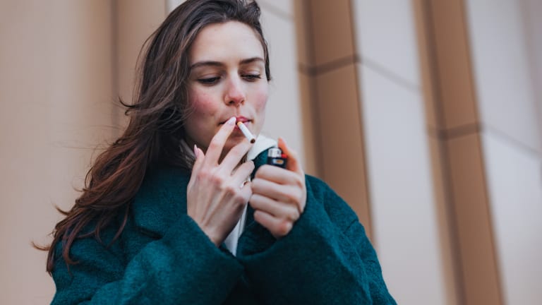 young woman smoking outdoors