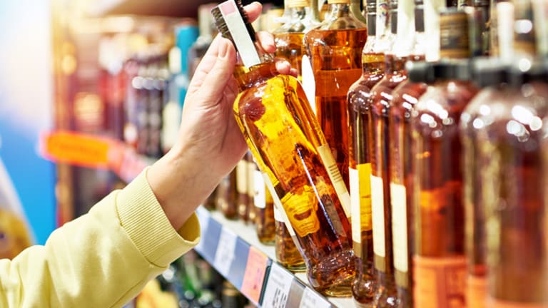 person grabbing bottle of whiskey