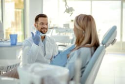 Zahnarzt im Gespräch mit einer Patientin