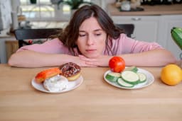 woman choosing between two meals