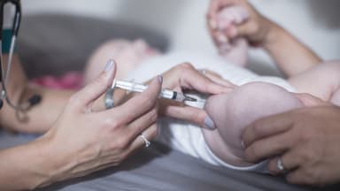 Baby wird in Oberschenkel geimpft